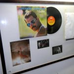 A framed glazed Queen collage featuring a signed copy of Freddie Mercury Mr bad guy